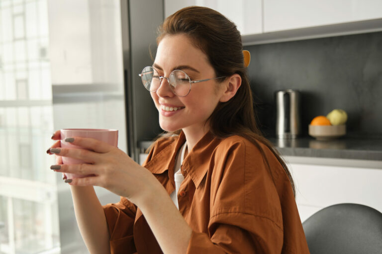 Portrait of young beautiful woman, relaxing with cup of fresh aroma coffee, holding mug and sitting in kitchen, smiling from happiness Ayuno terapéutico qué es y cómo puede ayudarte a sanar